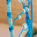blue wire closeup as it is wrapped and secured to yarn covered hoop